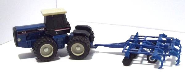 Blue Ford 876 Tractor turning with blue harrow